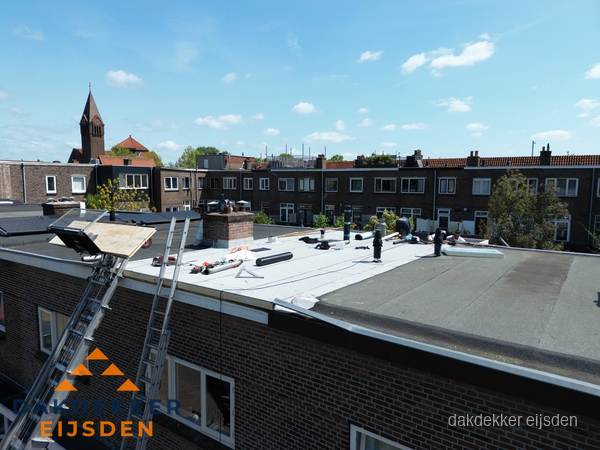 Dakdekkers aan het werk op plat dak in Eijsden