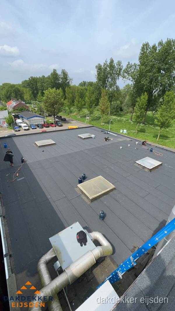 Dakdekker aan het werk op groot plat dak met bitumen in Eijsden Dakdekker aan het werk op groot plat dak met bitumen in Eijsden