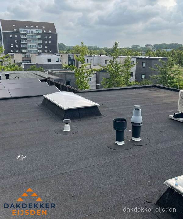 Groot plat dak met lichtkoepel en dakdoorvoeren in Eijsden
