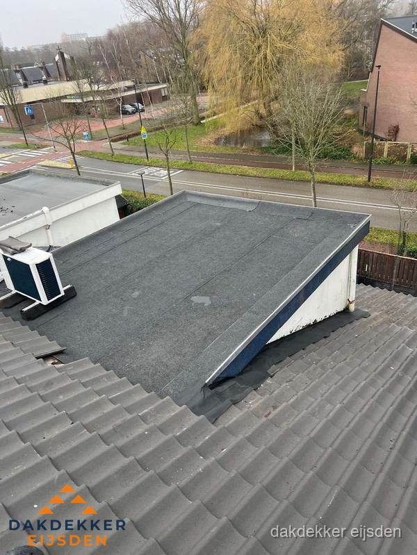 Plat dak met bitumen dakbedekking naast schuin pannendak in Eijsden
