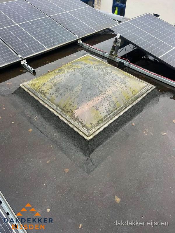 Vervuilde lichtkoepel op plat dak met zonnepanelen in Eijsden Vervuilde lichtkoepel op plat dak met zonnepanelen in Eijsden