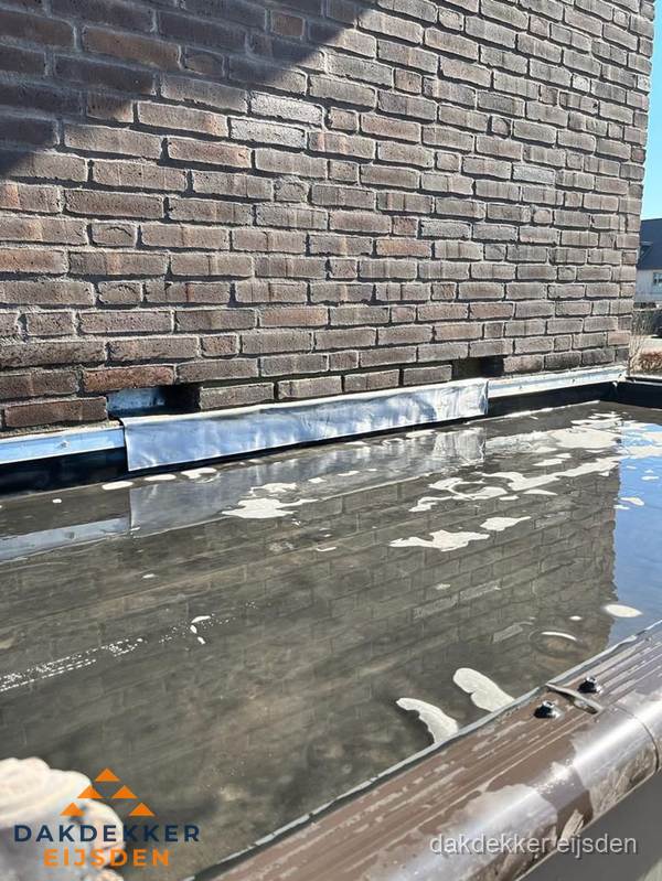 Stilstaand water op plat dak door slechte afwatering in Eijsden Stilstaand water op plat dak door slechte afwatering in Eijsden