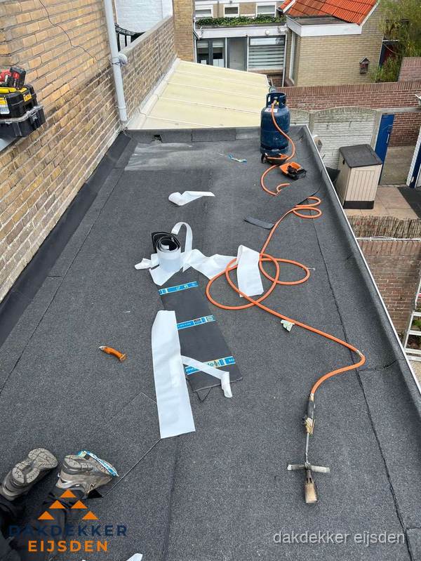Dakdekkers bezig met bitumen dakbedekking in Eijsden