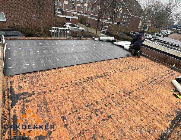 Dakdekker legt onderlaag op plat dak met houten constructie in Eijsden