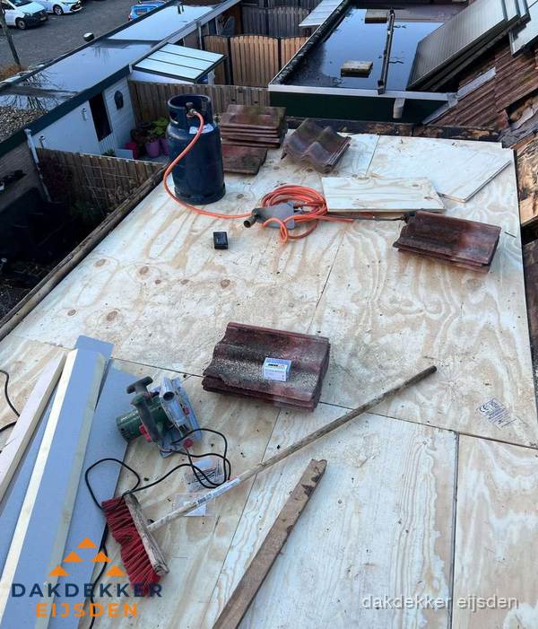 Dakreparatie werkzaamheden op plat dak met gereedschap in Eijsden