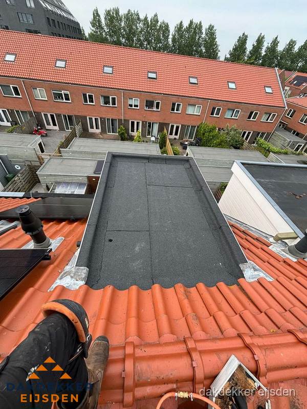 Bitumen dak reparatie op plat dak tussen dakpannen in Eijsden